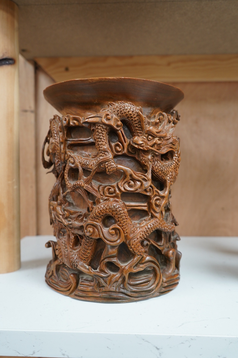 A 20th century Chinese carved hardwood ‘dragon’ brush pot, 22.5cm high. Condition - fair to good